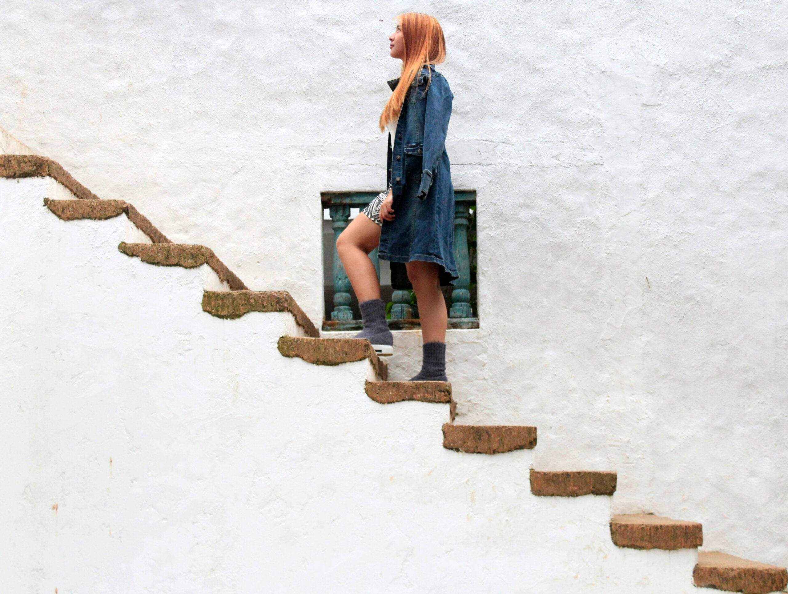 A woman standing on some steps, representing the moment before she feels ready to take the next step.