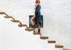 A woman standing on some steps, representing the moment before she feels ready to take the next step.