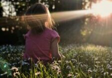 Person sitting quietly in the daisies reflecting on learning to trust yourself